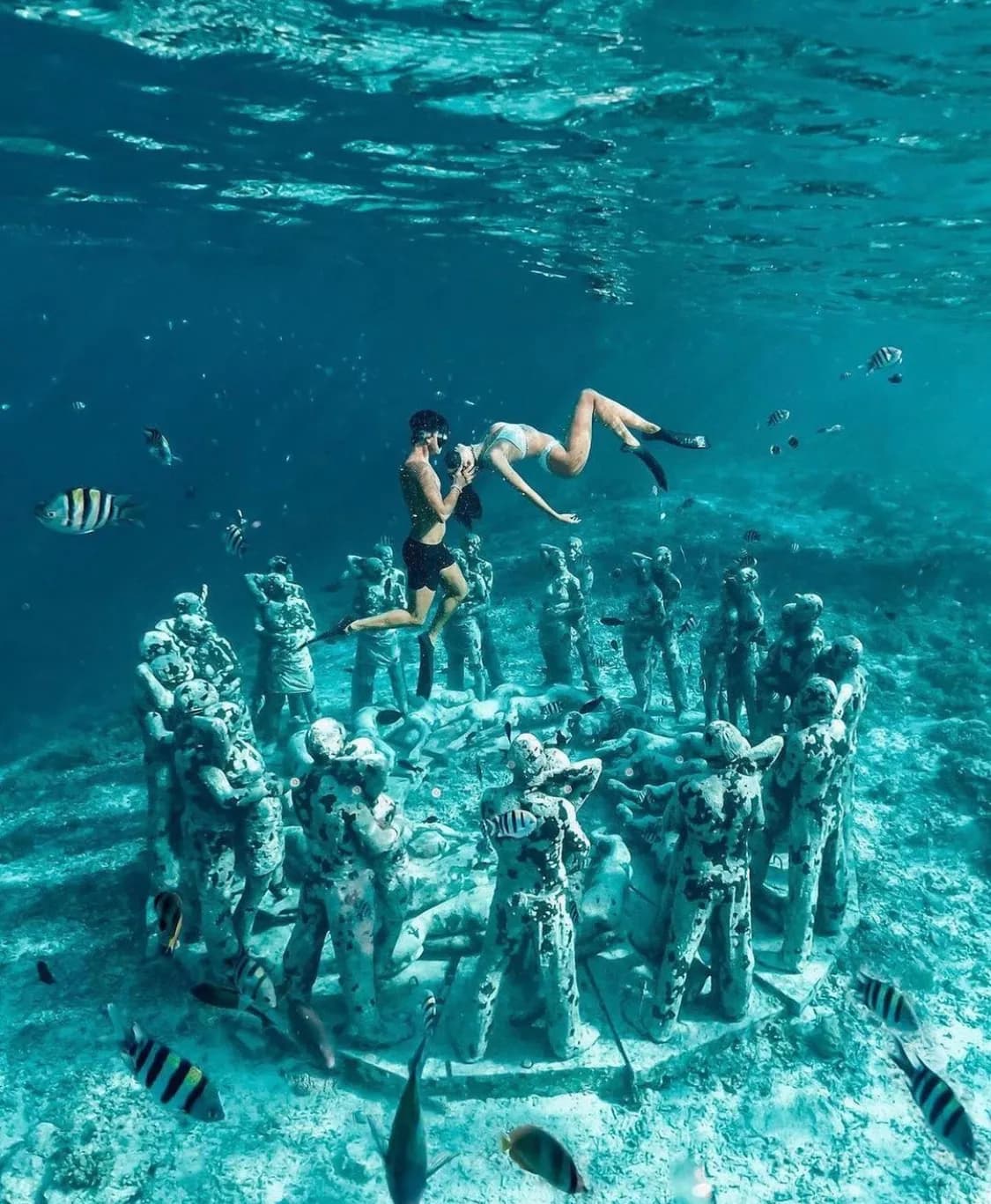 Diver descending along a wall off Gili Meno